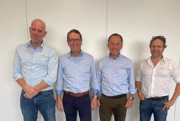 Four men standing in a line