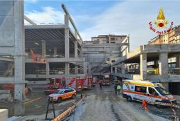 A picture of a building that was under construction but has collapsed with emergency vehicles