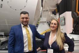 A man and a woman stading in front of a concrete mixer