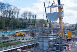 A concrete Y shaped block being lifted by a crane for a new railway viaduct