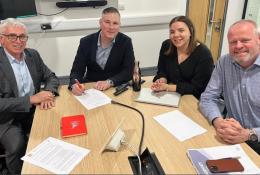 Three men and a woman sitting around a wooden table