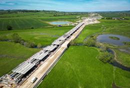 Aerial view of a Viaduct under construction surrounded by green fields