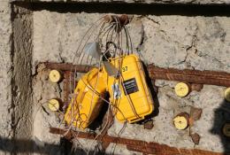 yellow boxes with lots of wires hanging on a newly poured concrete wall
