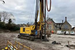 A yellow drilling rig on a constreuction site