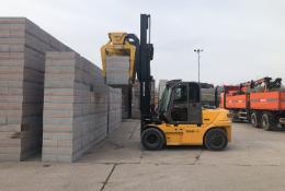 A yellow forlift stacking concrete plinths