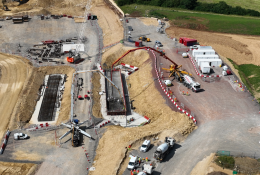 An aerial photo of a construction site with a red concrete pump