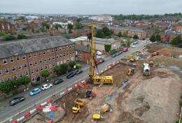 An aerial view of a housing development under construction with a yellow piling rig and other assorted plant.