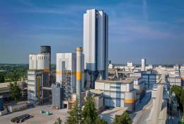 A white, grey and yellow cement plant against a blue sky