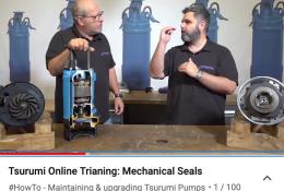 A bald headed man and a man with a beard behind a bench with a blue pump