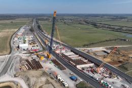An aerial view of three cranes as the prepare to install bridge beam on the A43 for HS2, March 2025.