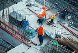Two PPE clad construction workers install rebar ties