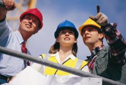 Three people in PPE. One in a red hard hat, one in blue and one in yellow.
