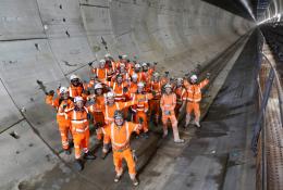 A group of construction workers gather in a tunnel to celebrate the completion of a 5 mile long tunnel under London as part of HS2