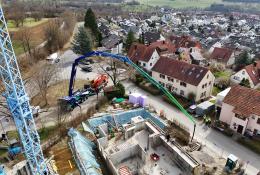 An aerial view of the new Volvo Trucks and Putzmeister fully electric alternative for pumping concrete in action on a construction site. 