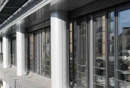 A glass fronted office with concrete columns.