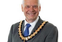 A photo of Paul Gandy, president, CIOB, wearing a grey suit, white shirt, blue tie and ceremonial chain.