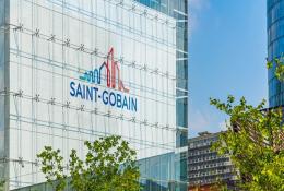 The blue and red Saint-Gobain logo on the side of a glass paneled, high-rise building.