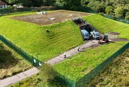 An aerial photo shows men in PPE and two vans at Stanley Hollowhouse following the installation of the cement-free, basalt-reinforced base for Scottish Water’s first verified Net Zero site.