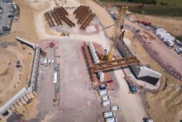 A yellow crane lifts beams into place for the Gloucestershire Way bridge, which will span the new A417 Missing Link and eight lanes of traffic