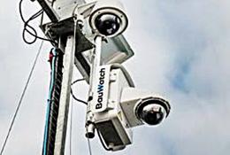A close-up view looking up at two solar powered CCTV cameras mounted on a pole.