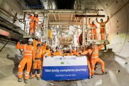 A large group of people in orange PPE, part of HS2 tunnelling team celebrates, TBM Emily completing 5.5km journey. Image: HS2.