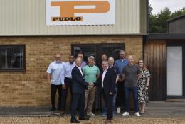 Malcolm Thornton and Scott Wilson (shaking hands) pictured with the PUDLO team outside their office following the deal to buy the company.