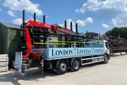 A blue London Lintels liveried truck with red loader crane mounted at the rear in London Lintels yard. London Lintels, now part of the Milbank Group, distributes concrete and steel lintels to customers across London and the South.