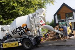 Two men unload concrete from one of Micromix’s agile trucks, which can deliver concrete loads from 0.5 to 4 m³, now with added convenience via online ordering.
