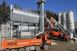An orange tipper truck and orange cement mixer wait by the new iMIX plant in Essex is MCT Italy’s first UK ready-mix installation, built for high-volume output and flexibility.