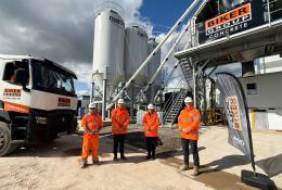 Four people in orange PPE stand in front of Biker Group’s new Stockton-on-Tees concrete plant, which represents a £1.5 million investment in the region.
