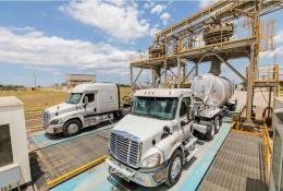 Two US trucks load up with materials at Eco Material Technologies, which supplies supplementary cementitious materials, critical for reducing embodied carbon in concrete.