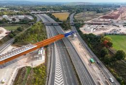 An aerial view of The HS2 viaduct East Deck being slid into place over the M6, supported by four pairs of reinforced concrete piers.