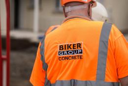 A construction worker in Biker Group branded orange PPE and hard hat