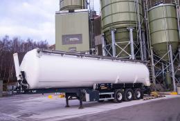 A white, material tanker standing in front of Material Evolution’s Mevo A1 Production Facility in Llay, Wrexham – the UK’s largest producer of ultra-low carbon cement, with a capacity of 120,000 tonnes per year.