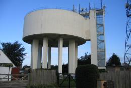 A view of a round concrete water tower and access tower