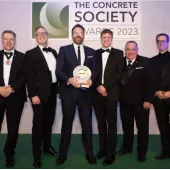 A group of men in dinner suits collect an award