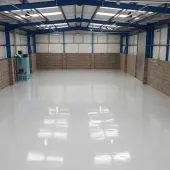 An interior view of an empty warehouse with an epoxy resin floor