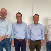 Four men standing in a line