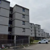 A row of mid-rise, grey, flats 
