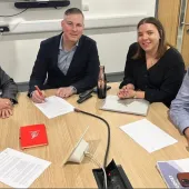 Three men and a woman sitting around a wooden table