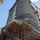A high rise under construction with yellow formwork 