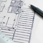 A black pen and a plan of a house with a white ruler