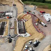 An aerial photo of a construction site with a red concrete pump