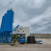 A concrete plant with three blue silos