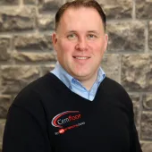A head and shoulders shot of a middle aged man in a black jumper