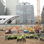 A large group of people wearing PPE in an urban construction site