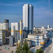A white, grey and yellow cement plant against a blue sky