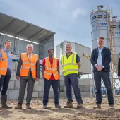 L–R: Prof. David Hughes; Bob Borthwick; Scott Bros recycling innovation engineer Feysal Shifa; Peter Scott; Joss Newberry; and Cassidy Smith, Teesside University’s IP and commercialization manager, standing in front of Scott Brothers new low-carbon concrete plant in Teeside.