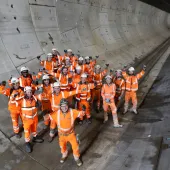 A group of construction workers gather in a tunnel to celebrate the completion of a 5 mile long tunnel under London as part of HS2