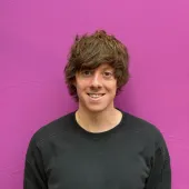 A head and shoulders shot of Joe Phelan, business savings expert at money.co.uk, against a pink wall.
